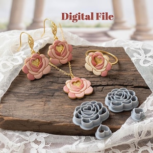 May include: A collection of floral jewelry and cookie cutters. The jewelry includes earrings, a necklace, and a ring, all featuring a pink and gold rose design. Gray plastic rose-shaped cookie cutters are also displayed. The text "Digital File" is visible.