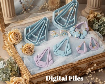 May include: A display of light blue and lavender polymer clay earring cutters and finished earrings. The cutters are in various sizes and shapes, with a geometric design. The earrings are displayed in a decorative gold-framed tray with dried flowers and the text "Digital Files".