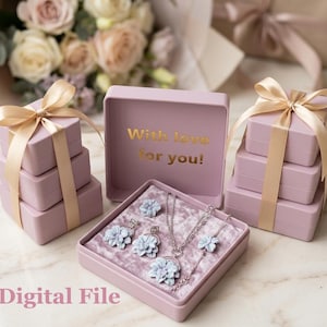 以下が含まれることがあります： ネックレス、イヤリング、ブレスレットのジュエリーセット。金色の文字で「With love for you!」と書かれたピンク色の箱に収められています。セットには青い花の形をしたアクセントがあります。箱は金色のリボンで結ばれています。