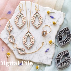 Op de afbeelding: Een collectie handgemaakte sieraden en polymeerklei-uitsteker. De sieraden omvatten een ketting, oorbellen, ring en armband, allemaal met een geometrisch ontwerp met roze, beige en grijze accenten. De tekst "Digital File" is zichtbaar.