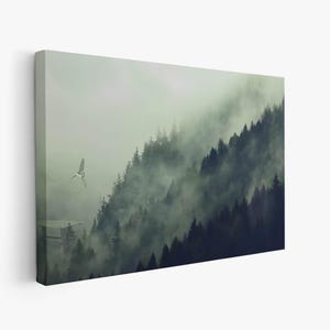 A framed rectangular canvas wall art showing a misty forest landscape with a small flying vehicle on the left side.