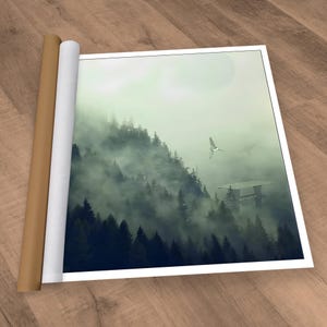 An unframed Star Wars print showing a misty forest landscape with a platform and two spacecraft, resting next to a rolled-up brown tube on a wooden surface.