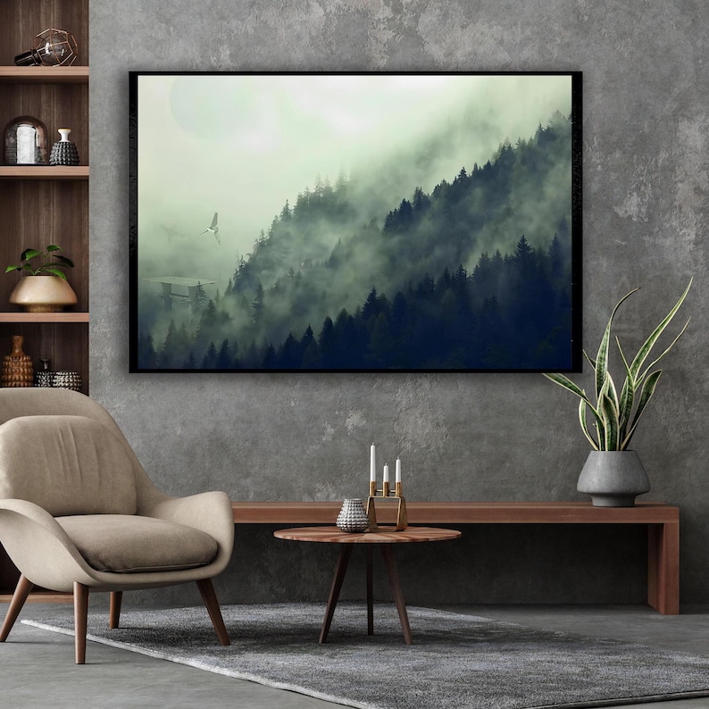 A framed canvas wall art of a misty forest landscape hangs on a textured grey wall above a console table and chair.