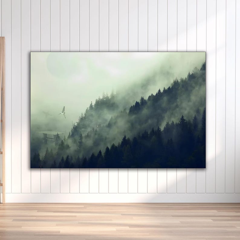 A horizontal framed canvas hanging on a white paneled wall depicting a misty pine forest landscape with a flying spacecraft.