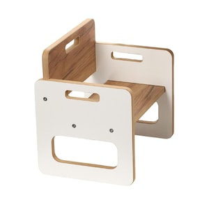 Könnte beinhalten: Ein kleiner Tritthocker aus Holz mit weißem Rahmen und Holzmaserung. Er hat eine rechteckige Form mit ausgeschnittenen Griffen. Der Hocker ist für Kinder konzipiert und misst etwa 30 cm in der Höhe.