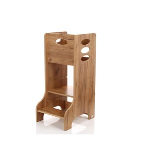 Puede incluir: Un taburete de madera con acabado marrón claro. Cuenta con una plataforma, un estante central y una sección superior con cortes ovalados. Los lados tienen soportes curvos. Diseño apto para niños.