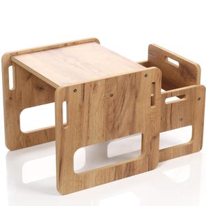 May include: A wooden children's table and chair set. The table has a rectangular top and is supported by four legs with cut-out handles. The chair has a similar design, with a backrest and a seat. The set is made of light brown wood.