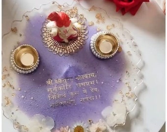May include: A decorative tray with a purple and white design, featuring gold accents and floral embellishments. The tray includes two small gold candle holders and a central floral arrangement. Red roses and text are also visible.