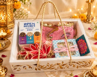 May include: A white gift basket with gold floral patterns containing an Open Secret assorted cookie box, a pink drawstring pouch with gold sequins, a red fabric lotus flower, a blue checkered box with a ribbon, and a small colorful greeting card.