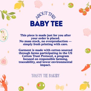 May include: A light pink informational graphic titled ABOUT THIS BABY TEE. It features dark blue text detailing made-to-order production and US Cotton Trust Protocol sourcing. The border is decorated with illustrations of lemons, olives, tomatoes, shells, and a lobster.
