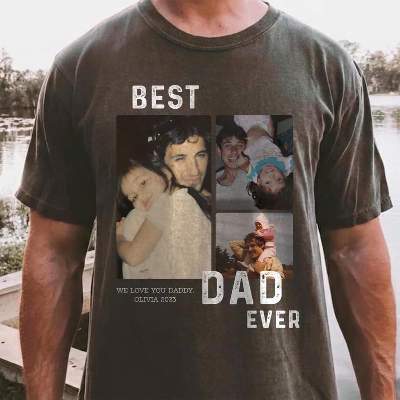Pode incluir: T-shirt verde-oliva escuro com uma colagem de fotos de fam&iacute;lia. A camisa tem as palavras "BEST DAD EVER" e "WE LOVE YOU DADDY, OLIVIA 2023" impressas. A camisa &eacute; de um estilo confort&aacute;vel e casual.