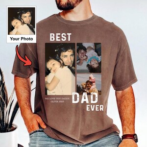 Pode incluir: Camiseta marrom com uma colagem de fotos de fam&iacute;lia e a frase "BEST DAD EVER". A camiseta inclui o texto "WE LOVE YOU DADDY, OLIVIA 2023" e um espa&ccedil;o para uma foto. Uma seta vermelha aponta para a &aacute;rea da foto.