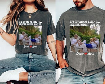 Puede incluir: Dos camisetas grises con el texto "IT'S YOU AND ME BABE - TILL THE BITTER, WRINKLY, SAGGY END..." y una foto de una pareja leyendo. Las camisetas también tienen los nombres "David" y "Anna" con un corazón.