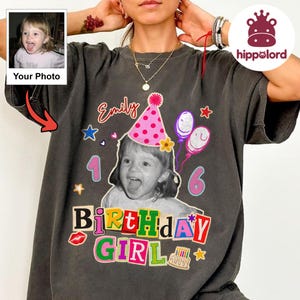 Può includere: Una t-shirt grigio antracite con una stampa grafica personalizzata di un bambino con un cappellino da festa rosa a pois, palloncini e il testo "Emily" e "16 BIRTHDAY GIRL". Il design include stelle colorate, una torta e un'icona di labbra rosse.