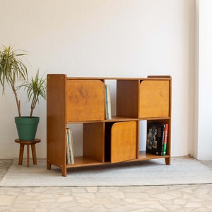 Mid-century modern sideboard made from eco-plywood, featuring hinged doors and open shelves to showcase decorative objects.