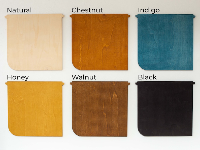 Może przedstawiać: Sześć drewnianych paneli w kolorach Natural, Chestnut, Indigo, Honey, Walnut i Black. Każdy panel ma unikalne usłojenie drewna i zaokrąglony narożnik, z nazwami kolor&oacute;w wyświetlanymi powyżej.