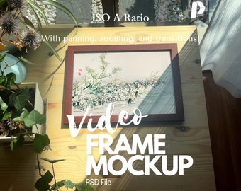 May include: A brown wooden frame with a white mat and a painting of a landscape inside. The frame is sitting on a wooden table with a plant in a pot in the foreground. The text "ISO A Ratio" is at the top of the image, and the text "Video Frame Mockup" is at the bottom of the image.