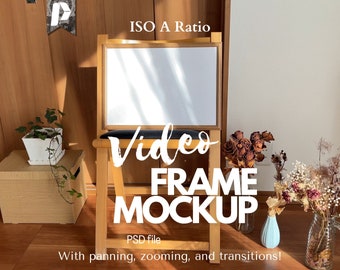 May include: A wooden frame mockup with a white background, sitting on a wooden chair. The frame is in an ISO A ratio. The text "Video Frame Mockup" is written in white letters on a black background. The text "PSD file" is written in white letters on a black background. The text "With panning, zooming, and transitions!" is written in white letters on a black background.
