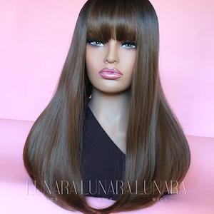 May include: A long, straight, brown wig with a fringe. The wig is styled with a center part and the ends are slightly curled under.