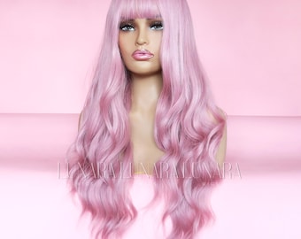 May include: A light pink wig with long, wavy hair and a fringe. The wig is displayed on a mannequin head against a pink backdrop. The text "LUNARA WIGS" is visible at the bottom.