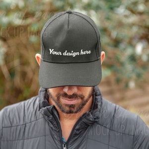 May include: A black mesh trucker hat with a white embroidered text that says "Your design here".