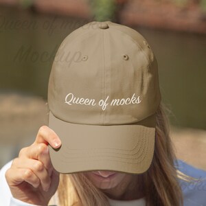 Puede incluir: Gorra de b&eacute;isbol beige con visera curva. El texto "Queen of mocks" est&aacute; escrito en cursiva en la parte delantera. La gorra est&aacute; hecha de un material suave y tiene un bot&oacute;n en la parte superior.
