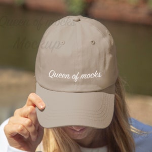 Puede incluir: Gorra de b&eacute;isbol beige con visera curva. El texto "Queen of mocks" est&aacute; escrito en cursiva en la parte delantera. La gorra est&aacute; hecha de tela suave y tiene un estilo cl&aacute;sico e informal.