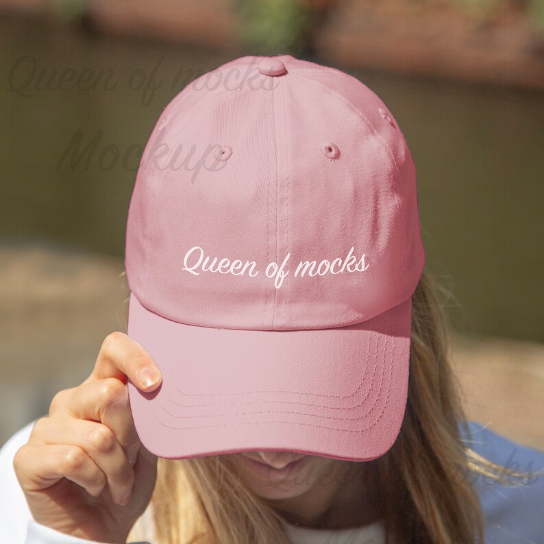 Puede incluir: Gorra de b&eacute;isbol rosa claro con visera curva. El texto "Queen of mocks" est&aacute; bordado en blanco en la parte delantera. La gorra est&aacute; hecha de un material suave y tiene un dise&ntilde;o cl&aacute;sico de seis paneles.