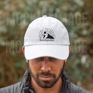 May include: White baseball cap with a black mountain and sun graphic and the text "Your design here".