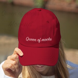Puede incluir: Gorra de b&eacute;isbol roja lisa con visera curva. El texto "Queen of mocks" est&aacute; bordado en blanco en la parte delantera. La gorra est&aacute; hecha de un material suave y tiene un dise&ntilde;o cl&aacute;sico de seis paneles.