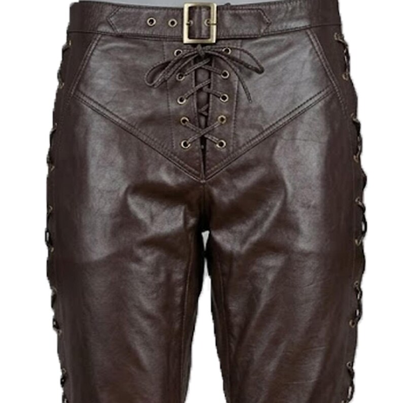 May include: Brown leather pants with a lace-up front and side detailing. The pants feature a buckle closure at the waist and eyelets along the sides for the lacing. The leather has a slight sheen.