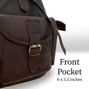 May include: A dark brown leather bag featuring a front pocket with a flap, a brass-toned metal buckle closure, and visible stitching. The text "Front Pocket 6 x 5.5 inches" is printed on the right side of the bag, indicating its specific dimensions.