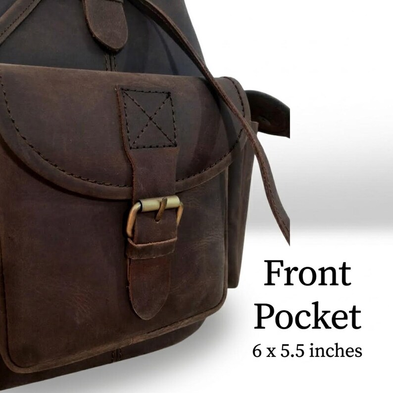 May include: A dark brown leather bag featuring a front pocket with a flap, a brass-toned metal buckle closure, and visible stitching. The text "Front Pocket 6 x 5.5 inches" is printed on the right side of the bag, indicating its specific dimensions.