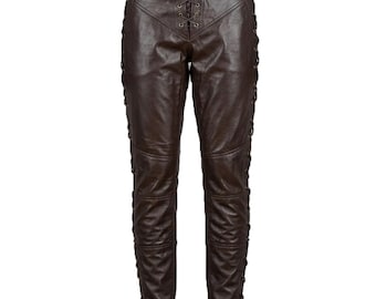 May include: Brown leather trousers featuring a lace-up front and sides. The trousers have a belt with a gold buckle. The leather has a distressed appearance, giving a vintage aesthetic. The design includes multiple panels and stitching.