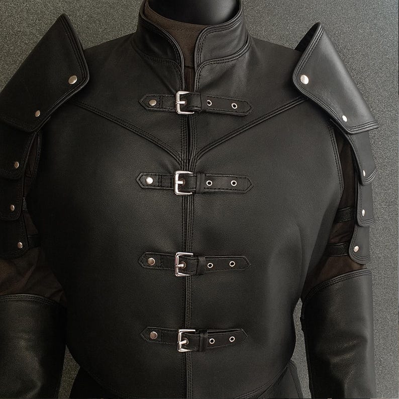 以下が含まれることがあります： 黒い革のジャケット、肩当て、シルバーのバックル。 ジャケットはハイカラーで、前面にはバックル付きの複数のストラップが付いています。 肩当てはシルバーのリベットで取り付けられています。 ジャケットは中世またはファンタジーのスタイルです。
