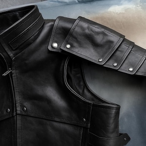 May include: Close-up of a black leather jacket with a high collar and shoulder armor detailing. The jacket features silver-toned snap closures and intricate stitching. The design suggests a vintage or biker-inspired aesthetic.