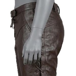 May include: Brown leather pants with a belt and lace-up detailing on the sides. The pants have a classic design with visible stitching and a fitted silhouette. The leather appears to be of high quality, with a slightly textured surface.