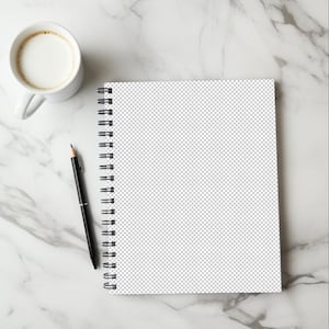 May include: A white spiral bound notebook with a black pen on a white marble surface.
