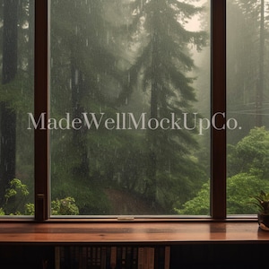 May include: A window with a view of a lush green forest in the rain. The window is framed by wooden bookshelves filled with books. The text "MadeWellMockUpCo." is visible in the center of the window.