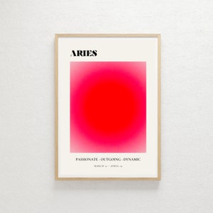 May include: A framed poster with a pink and red gradient background and the text "ARIES" in black. The text "PASSIONATE - OUTGOING - DYNAMIC" is below the gradient, and the dates "MARCH 21 - APRIL 19" are below that.