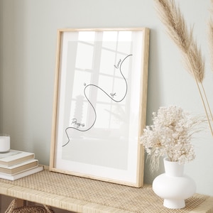 May include: A framed print with a black line drawing of a wavy line with the text "Progress is not linear" on a white background.