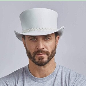 Puede incluir: Un sombrero de copa blanco con una banda trenzada alrededor de la corona. El sombrero est&aacute; hecho de un material liso y parecido al fieltro.