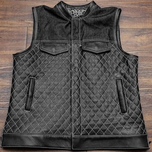 Pu&ograve; includere: Gilet in pelle nera con colletto in denim e trapuntatura a rombi. Il gilet ha due tasche sul davanti e due tasche sui lati.