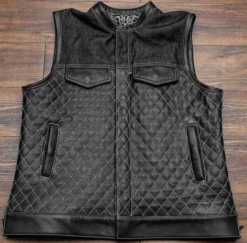 Pu&ograve; includere: Gilet in pelle nera con colletto in denim e trapuntatura a rombi. Il gilet ha due tasche sul davanti e due tasche sui lati.