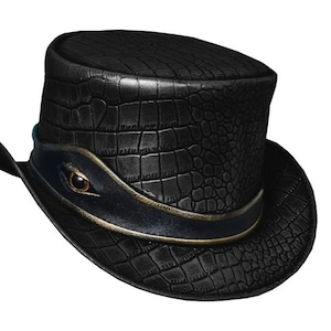 May include: A black top hat with a crocodile-embossed leather finish. The hat has a wide brim and a gold trim around the crown.