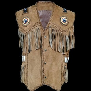 Pode incluir: Um colete de camurça marrom com franjas e detalhes de contas. O colete tem fecho de botão e gola pontiaguda.