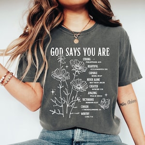 a woman wearing a t - shirt that says god says you are