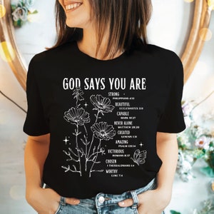 a woman wearing a black t - shirt that says god says you are