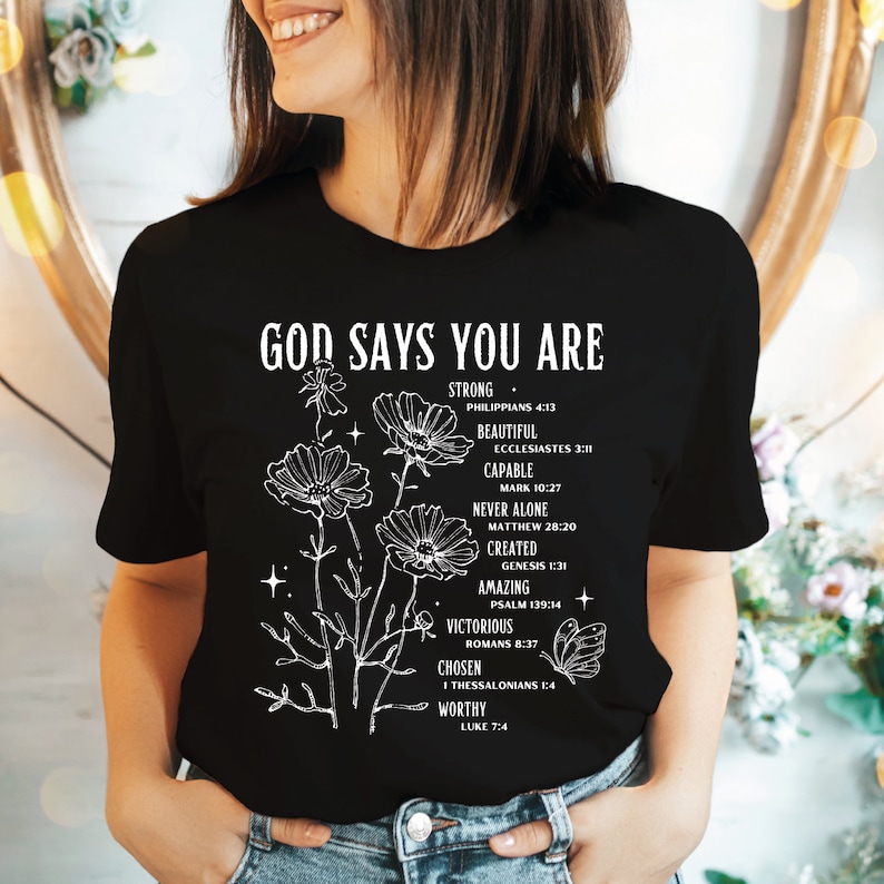 a woman wearing a black t - shirt that says god says you are