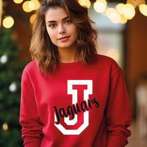 May include: Red sweatshirt with a white letter "J" and the word "Jaguars" in black script.